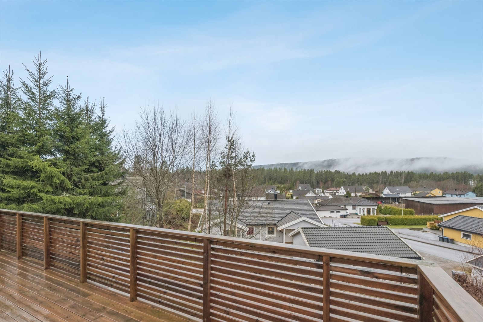 Utsikt fra terrassen viser et etablert boligområde med flotte turterreng. Galleribilde
