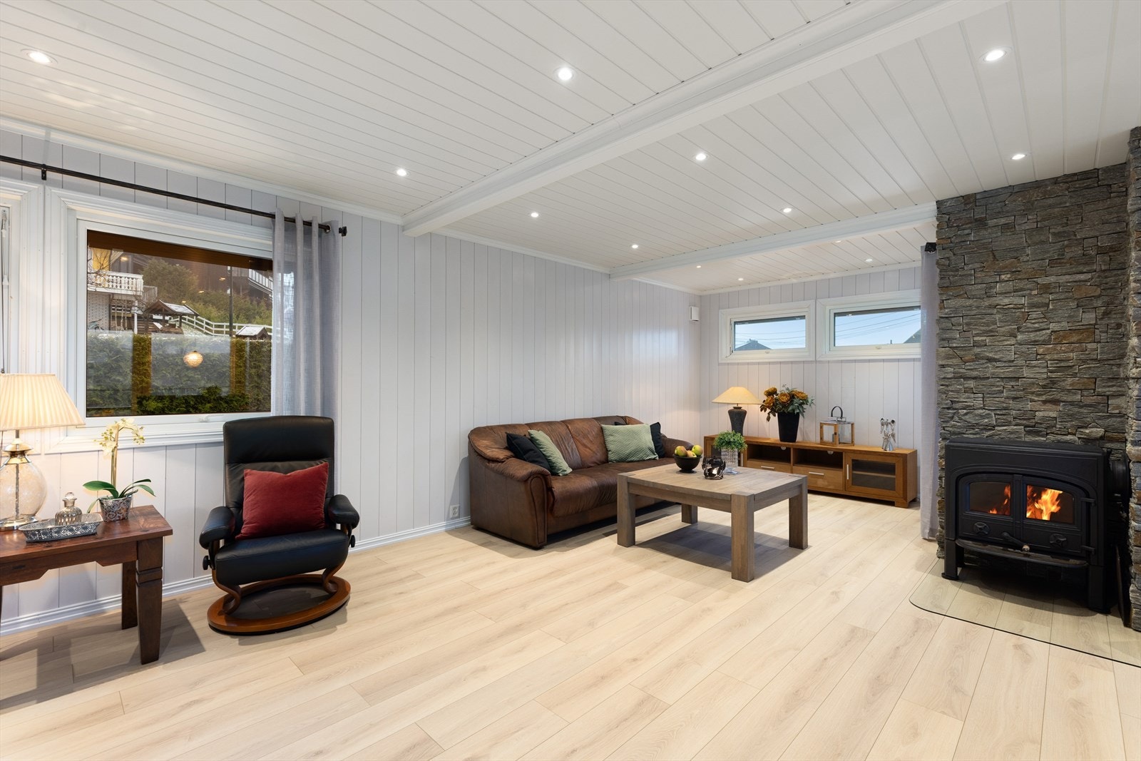 I deler av stua er det en dekorativ skiferpanel på veggoverflatene, og det er down-light belysning i tak. Galleribilde
