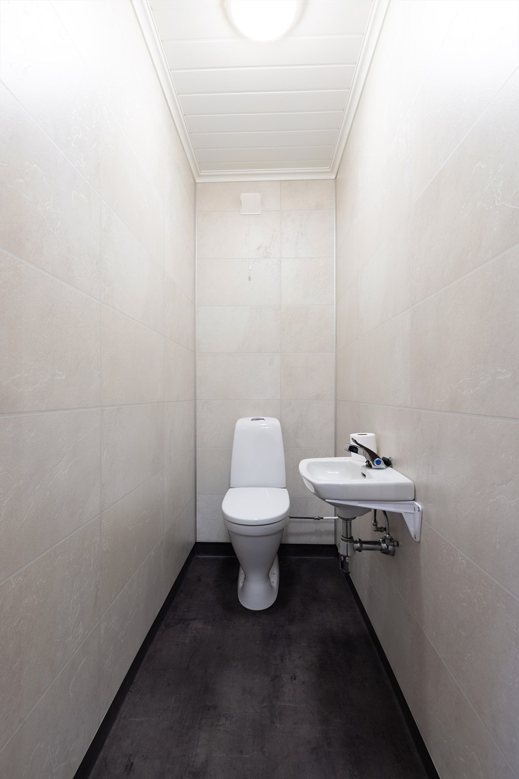 Også toalettrommet er renovert i 2022 og har samme overflater som vaskerommet. Også her er det varmekabler i gulvet. Enkel servant på vegg. Galleribilde