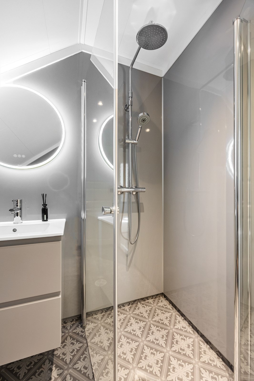 Her er det elektriske varmekabler i gulvet og et moderne preg med nedfelt servant og belyst speil. Galleribilde