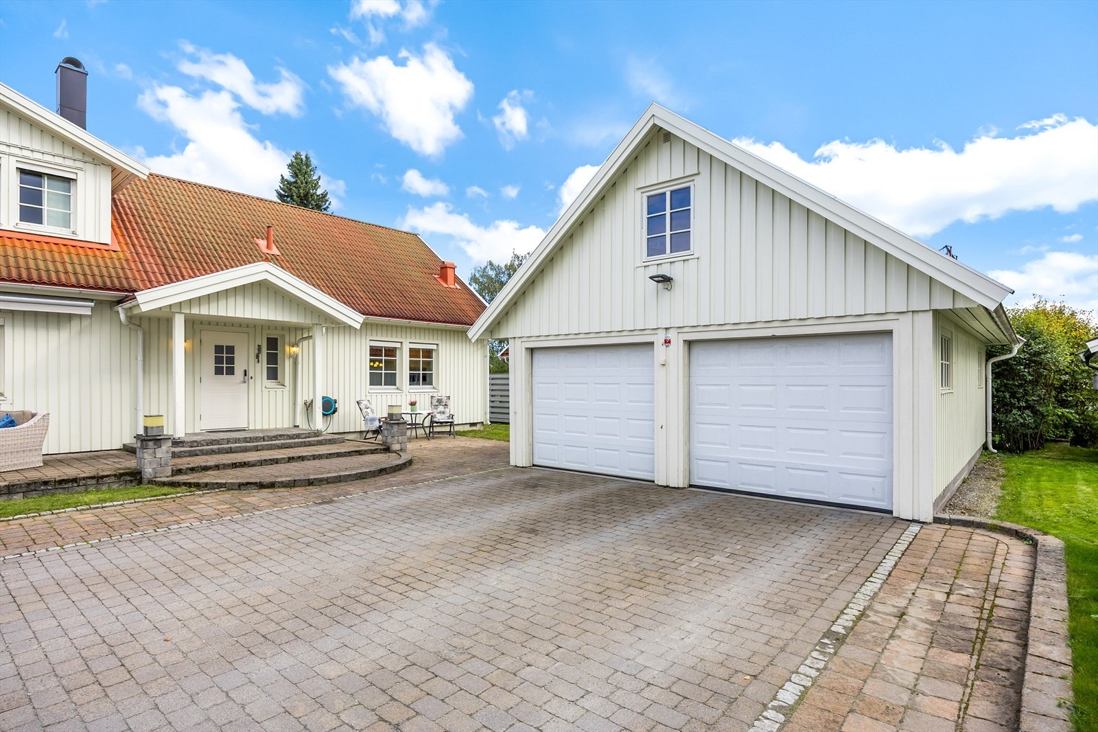 Den frittliggende garasjen har to leddporter med elektrisk styring (Den ene garasjeporten er skadet og må åpnes og lukkes manuelt) og innlagt strøm. Galleribilde