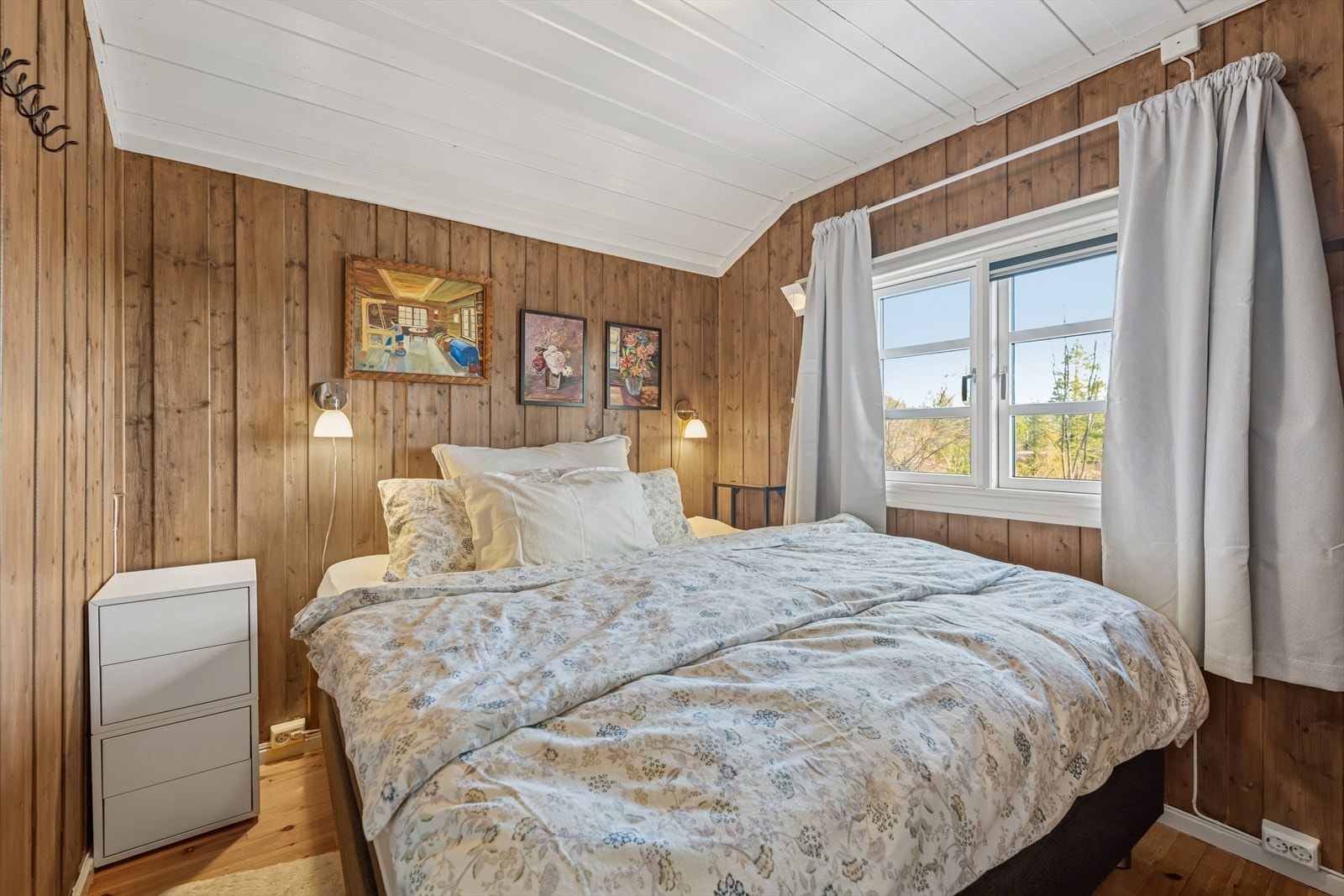 Romslig soverom med plass til dobbeltseng. Vegger av trepanel gir et rustikt preg til soverommet. Galleribilde