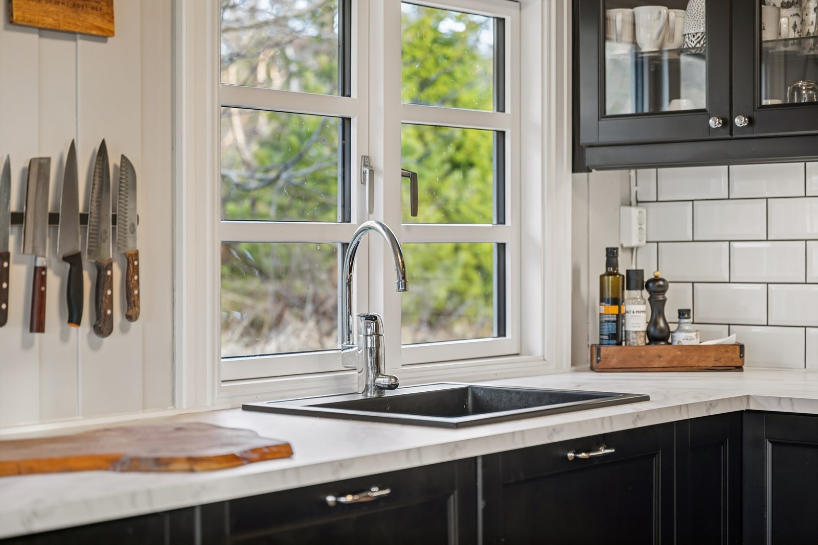 Kjøkkenvasken er plassert ved vinduet, gir utsyn mot pent grøntområde. Galleribilde