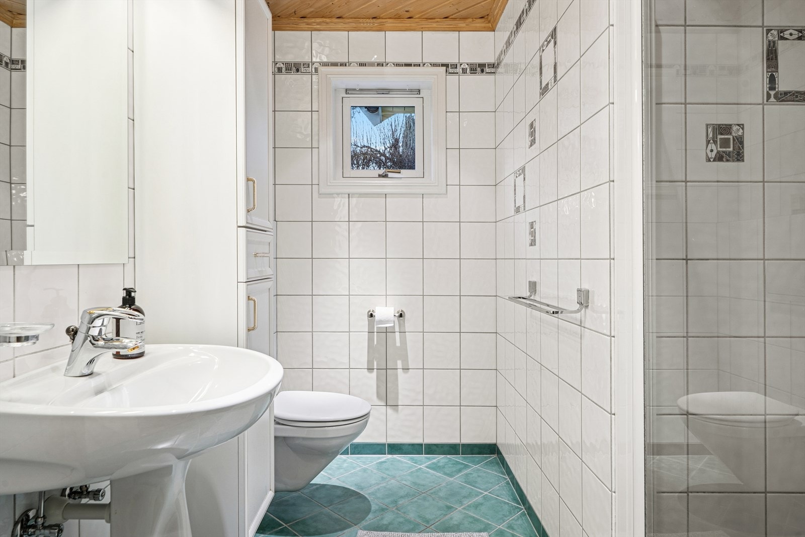 Badet i første etasje er fra byggeåret og har flislagte overflater. Her er det vannbåren gulvvarme som resten av første etasje. Galleribilde