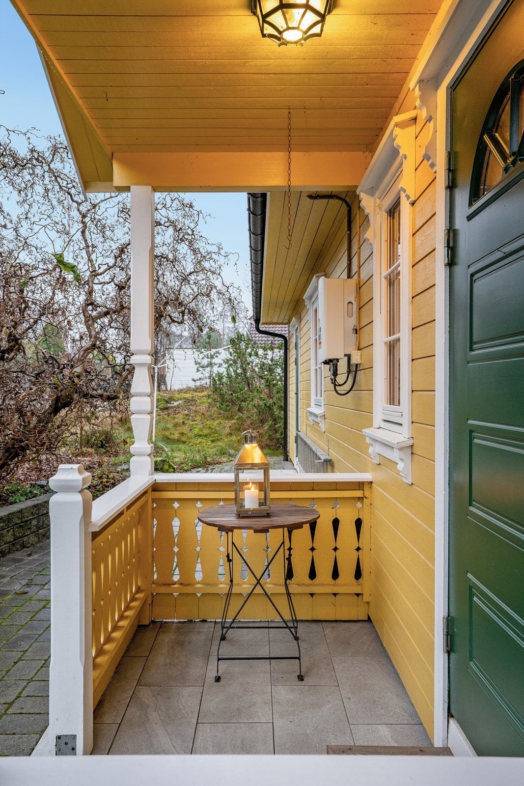 Overbygget inngangsparti med flislagt gulv gir et beskyttet område ved inngangsdøren. Galleribilde