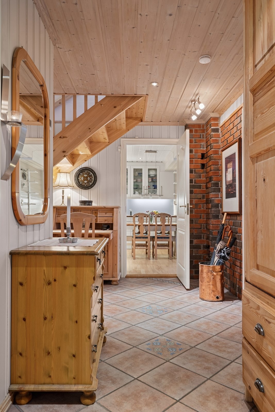 Fliser på gulvet og panel i taket gir en varm atmosfære i entréen. Galleribilde