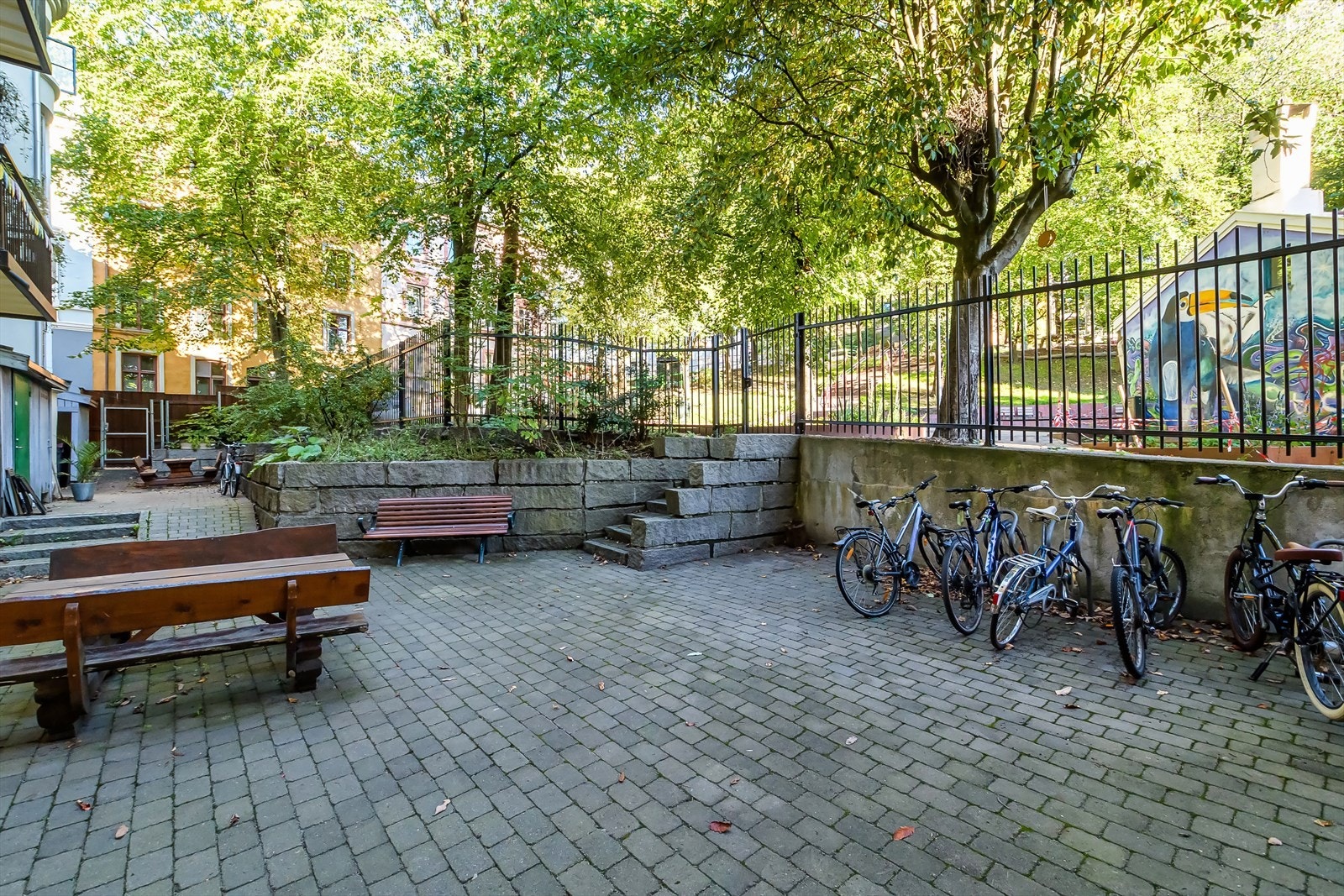 Låst port fører deg direkte til nyoppussede Gartnerløkka med sitteplasser, lekeplass og grøntareal. Galleribilde