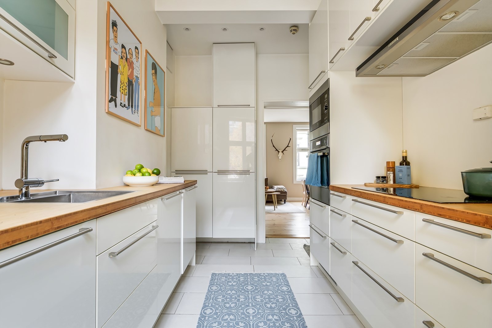 Lune fargetoner på veggene og flislagt gulv med behagelig gulvvarme gir kjøkkenet et tidløst og praktisk uttrykk. Galleribilde