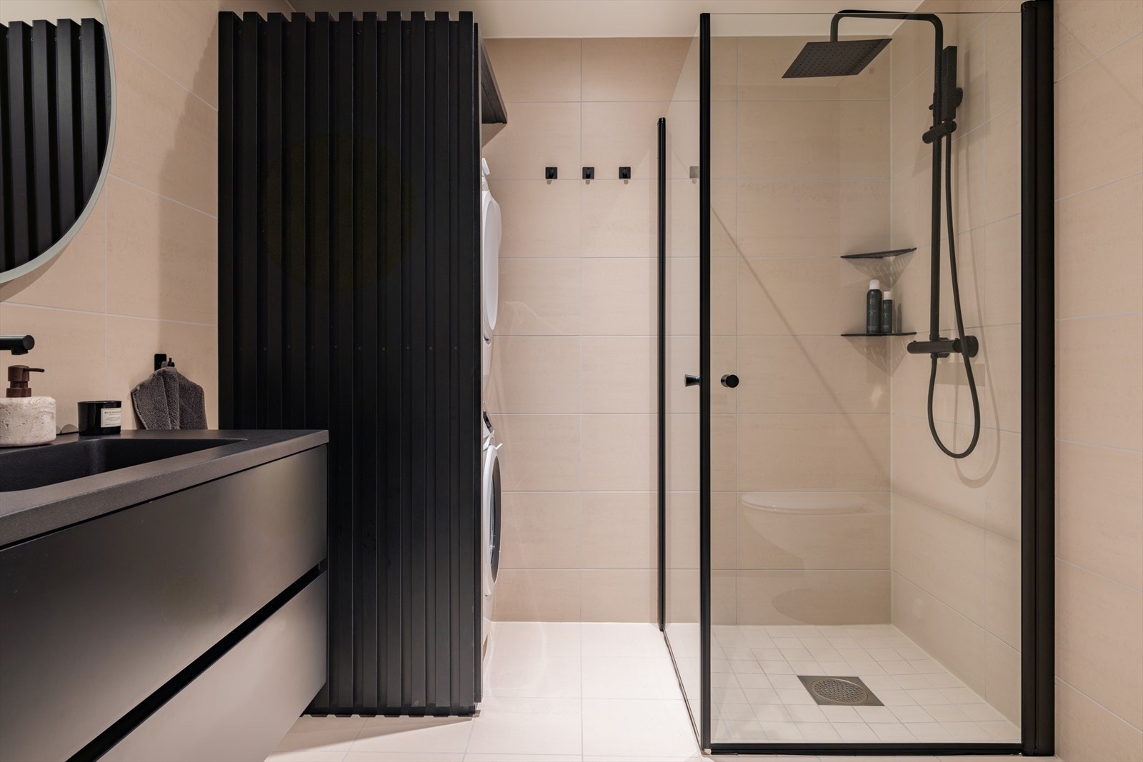 Lekkert flislagt bad med regnfallsdusj og sorte detaljer Galleribilde