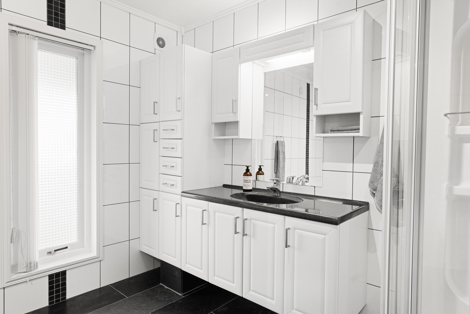 Baderom har vask i seksjon med rikelig skap- og skuffeplass. Galleribilde