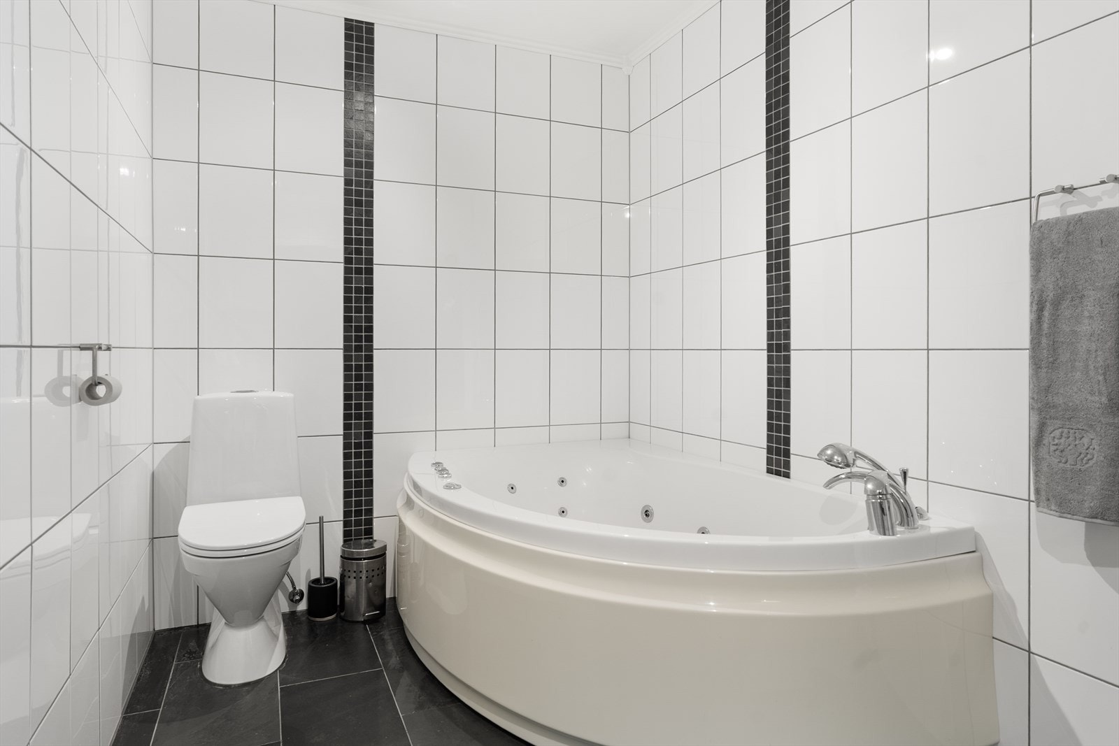 Boligen har flislagt baderom med boblebad, dusj og servant i seksjon. Galleribilde