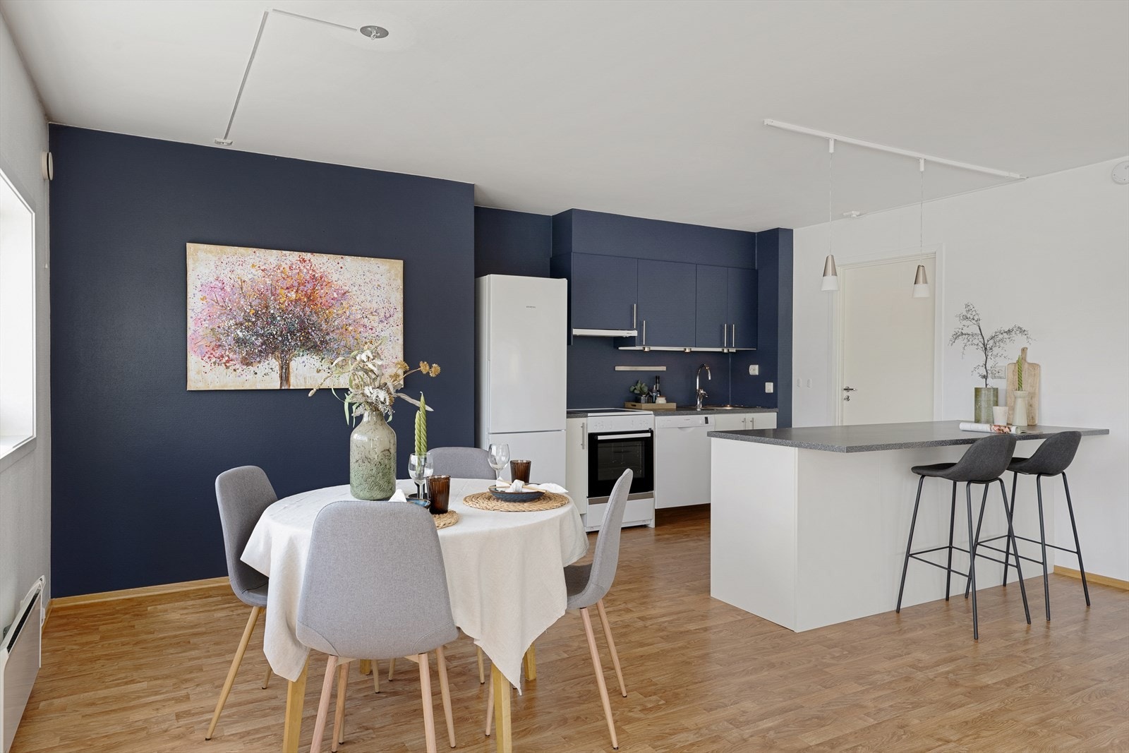 Kontrastvegg i lun blåfarge på kjøkkenspisestue. Galleribilde