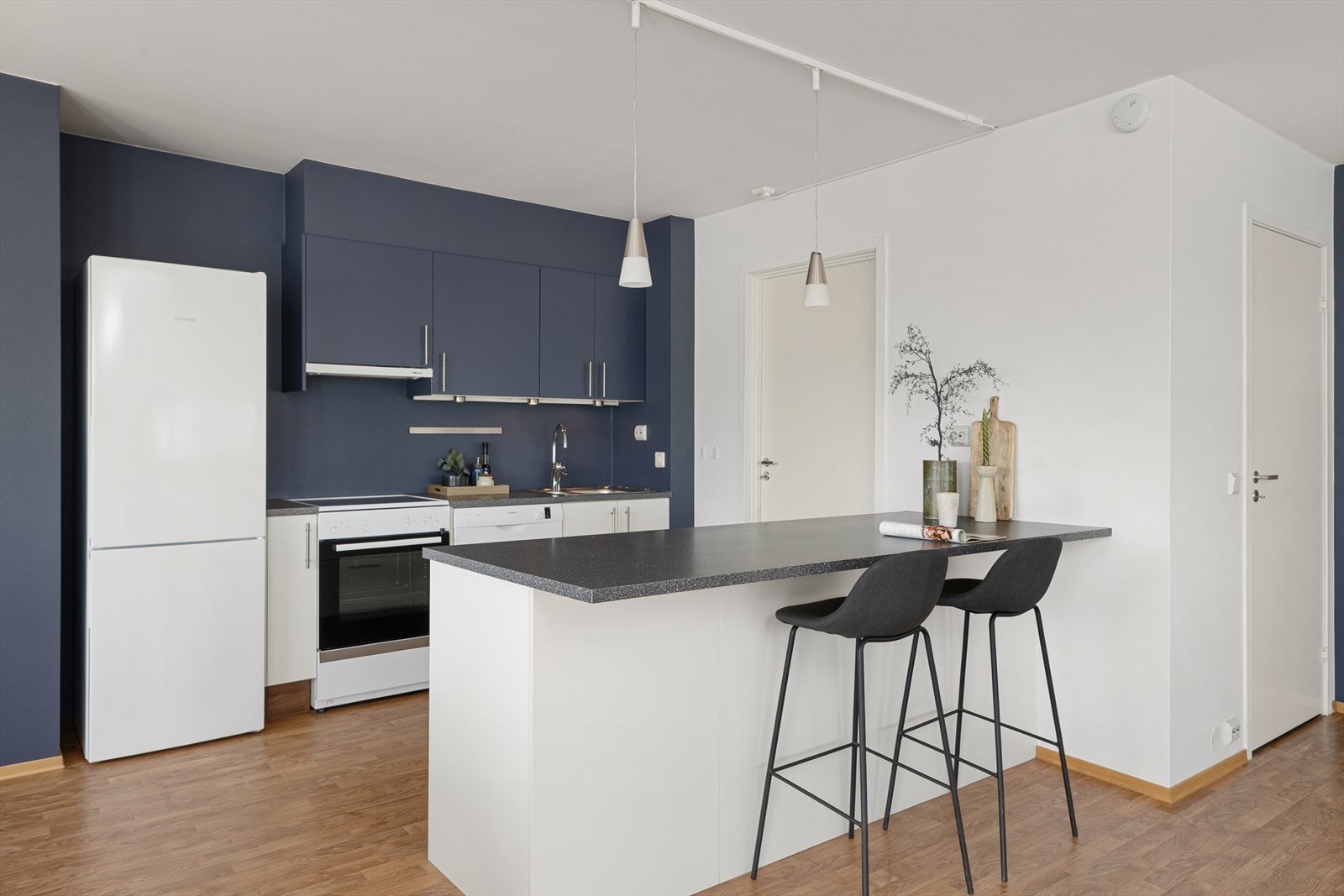 Kjøkkenøy med spiseplass og dør ut til entre. Galleribilde