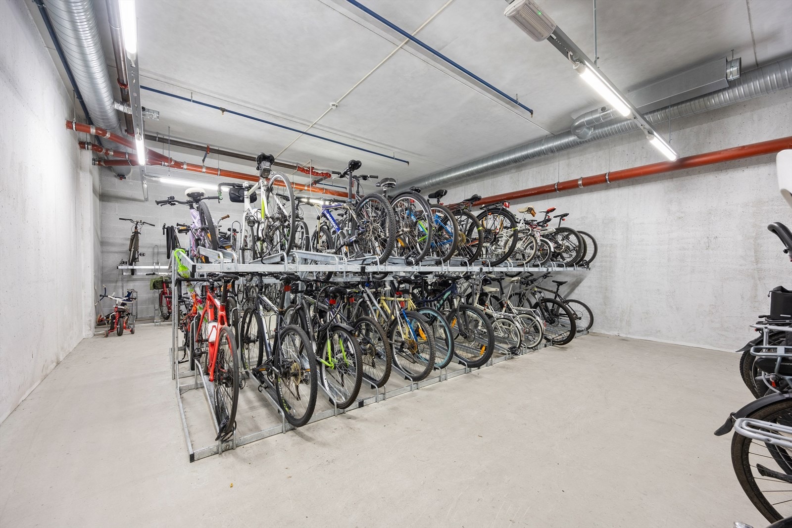 Sikker og romslig sykkelparkering i fellesareal i kjelleren. Galleribilde