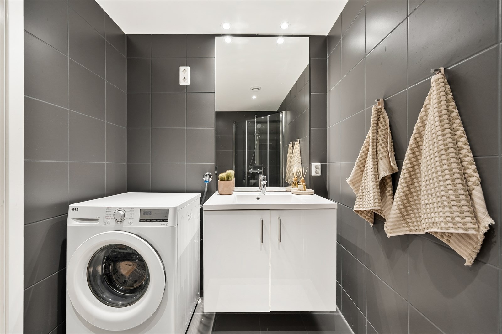 Praktisk plassering for vaskemaskin ved siden av servanten. Galleribilde