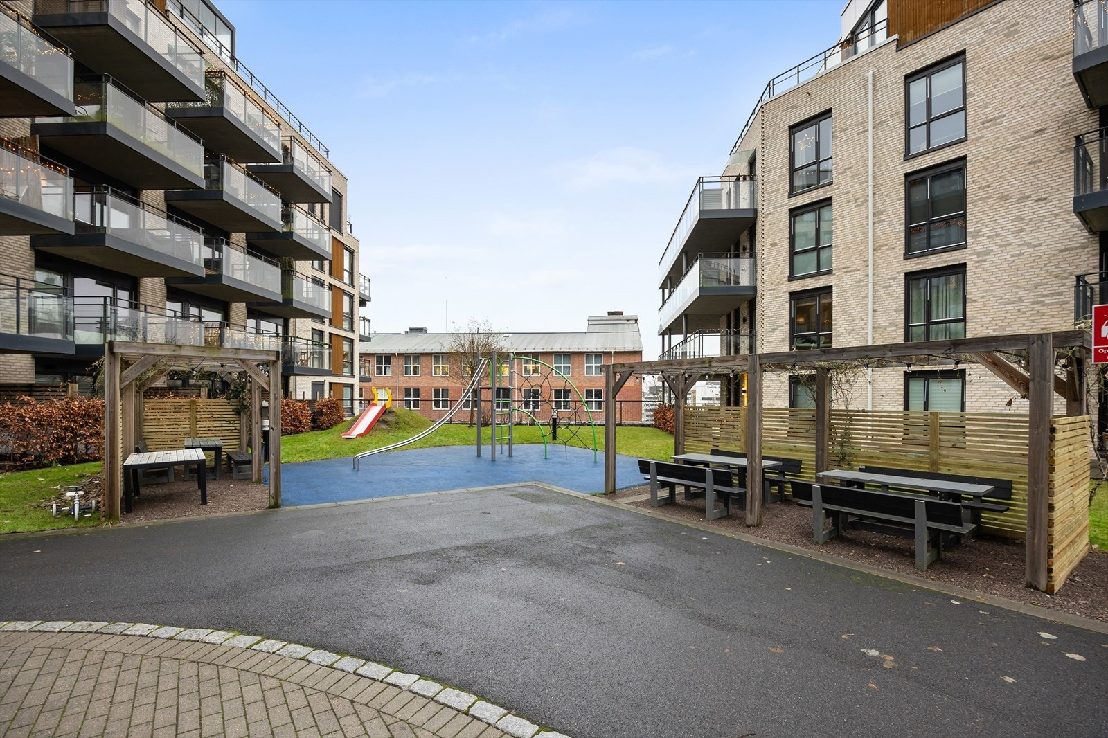 Felles lekeplass og sittegrupper i et skjermet og bilfritt gårdsrom. Galleribilde