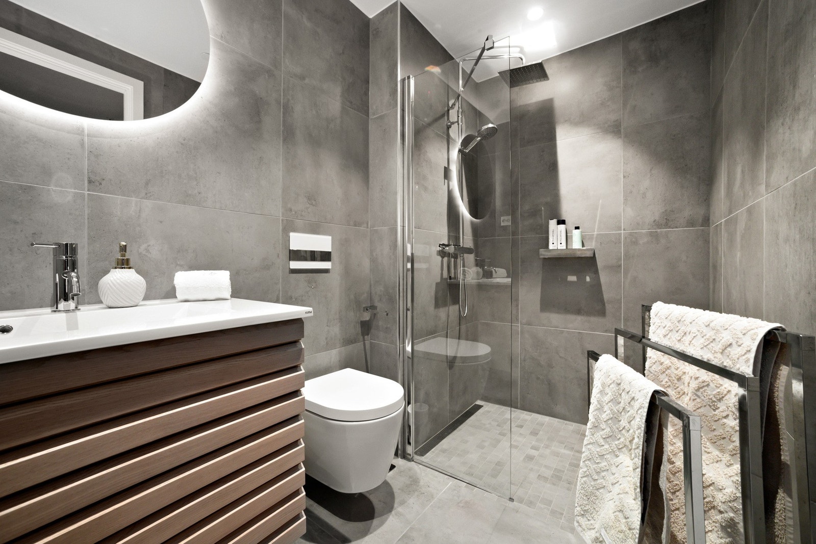 Lekkert bad med vegghengt toalett, dusjhjørne med regnfallsdusj og hånddusj. Lekker badromsinnredning med speil. Galleribilde