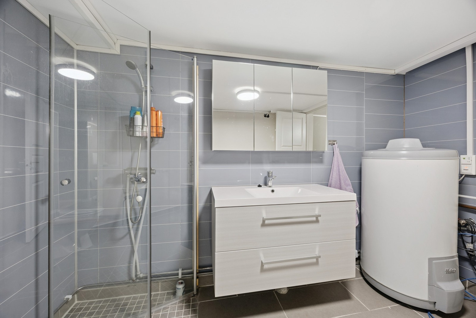 Badet er innredet med nedfelt servant, toalett og dusjhjørne Galleribilde