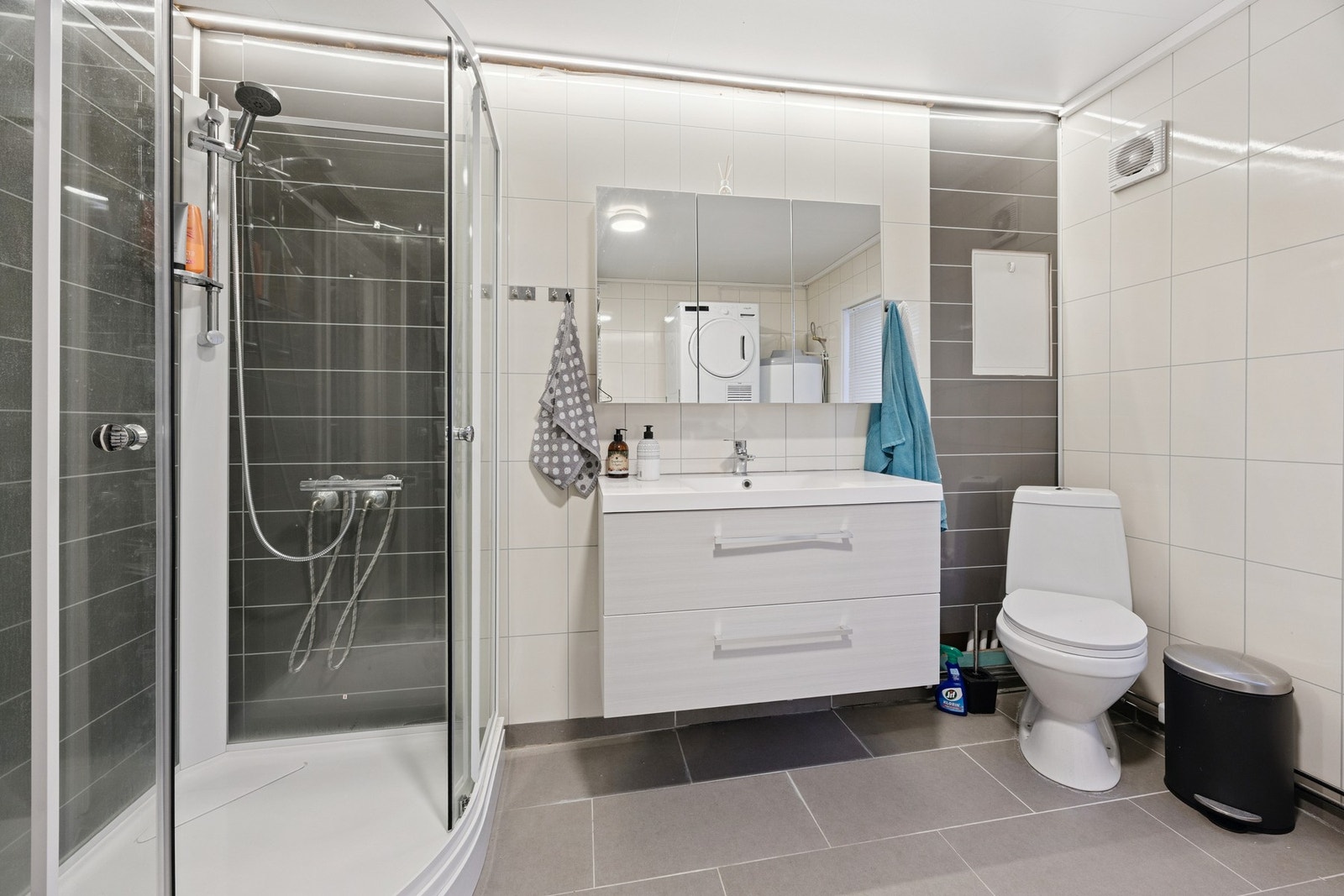 Badet er innredet med nedfelt servant, toalett, dusjkabinett og opplegg for vaskemaskin Galleribilde