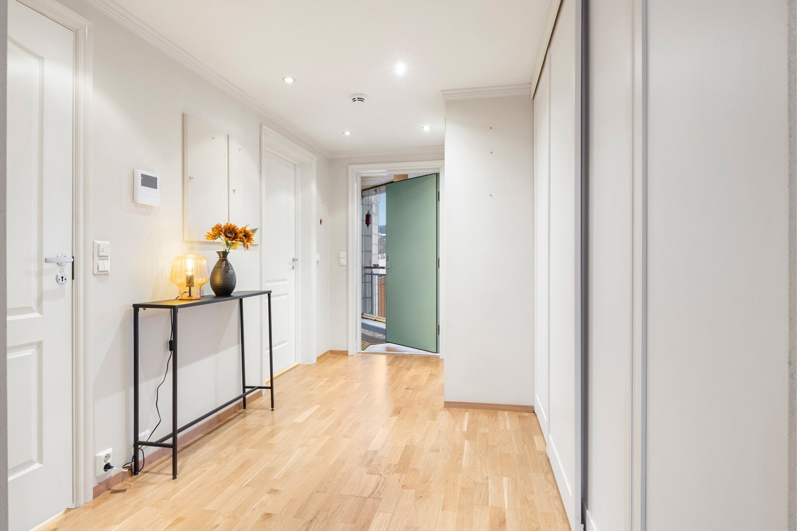 Videre kommer man inn i en romslig entré med porttelefon og praktisk skyvedørsgarderobe. Galleribilde