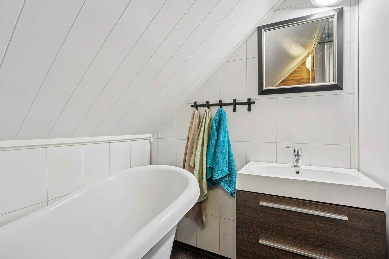 Her finner du et flott badekar, vegghengt servantinnredning med heldekkende servant samt toalett. Galleribilde