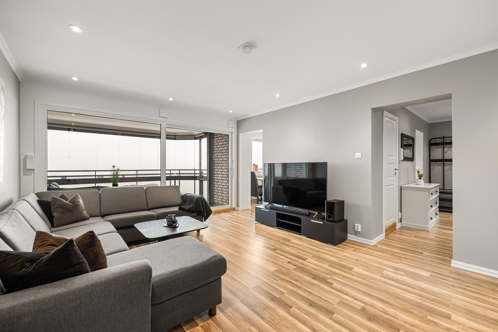 Romslig og lys stue. Med stor skyvedør til utgang til innglasset balkong. Galleribilde