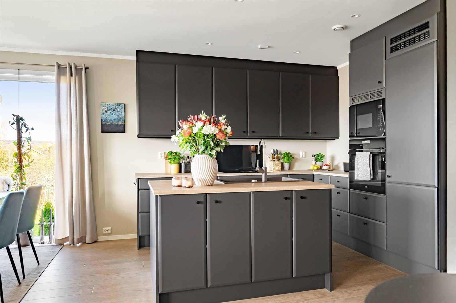 Stort kjøkken med en praktisk kjøkkenøy. Galleribilde