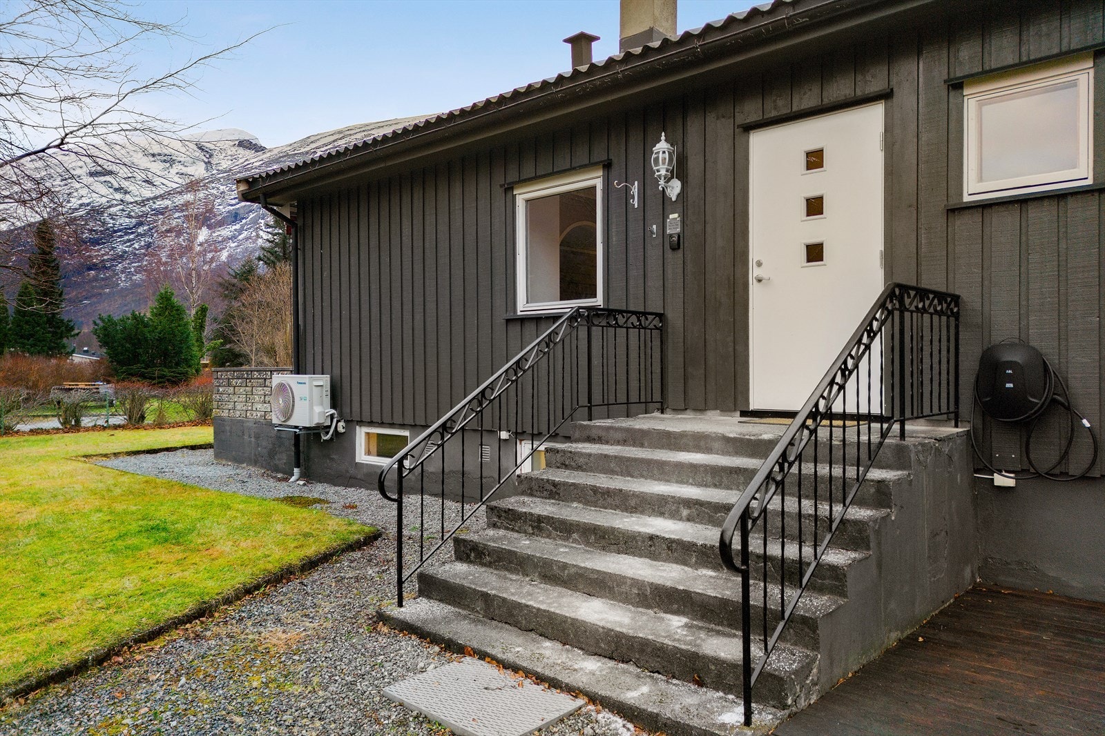 Inngangsparti med trapp og gelender gir enkel adkomst til boligen. Elbillader montert på veggen. Galleribilde