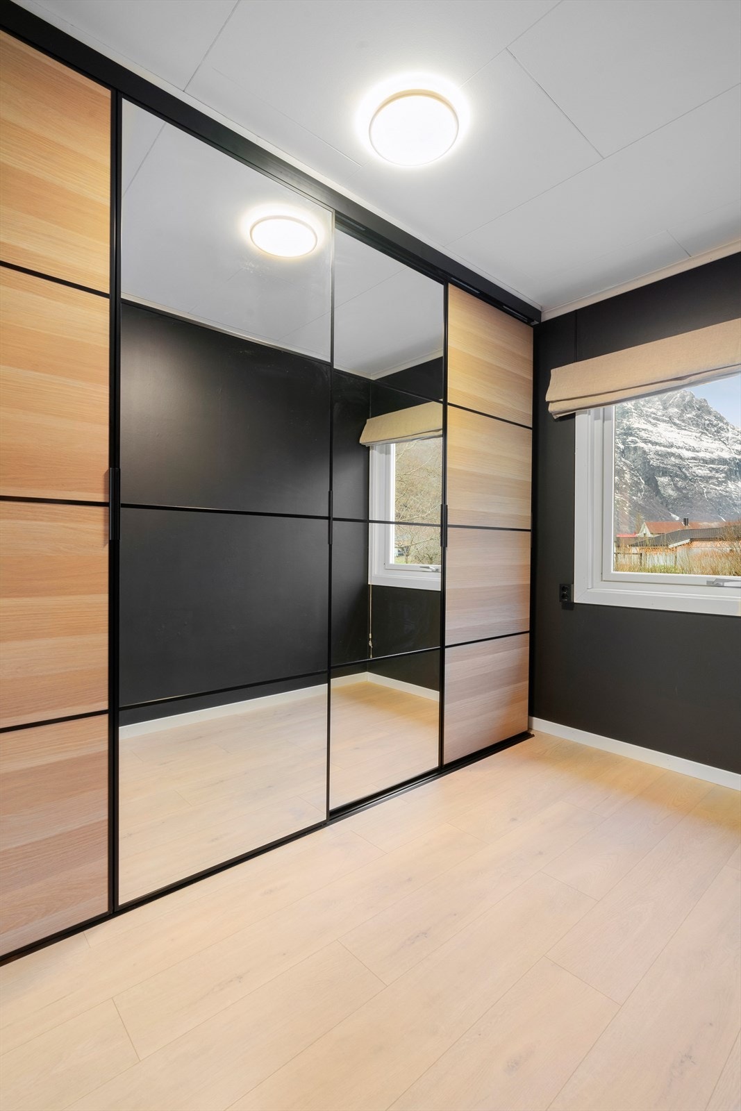 Skyvedørsgarderobe med speil gir god oppbevaringsplass og romfølelse. Vinduet gir utsikt mot fjellandskap. Galleribilde