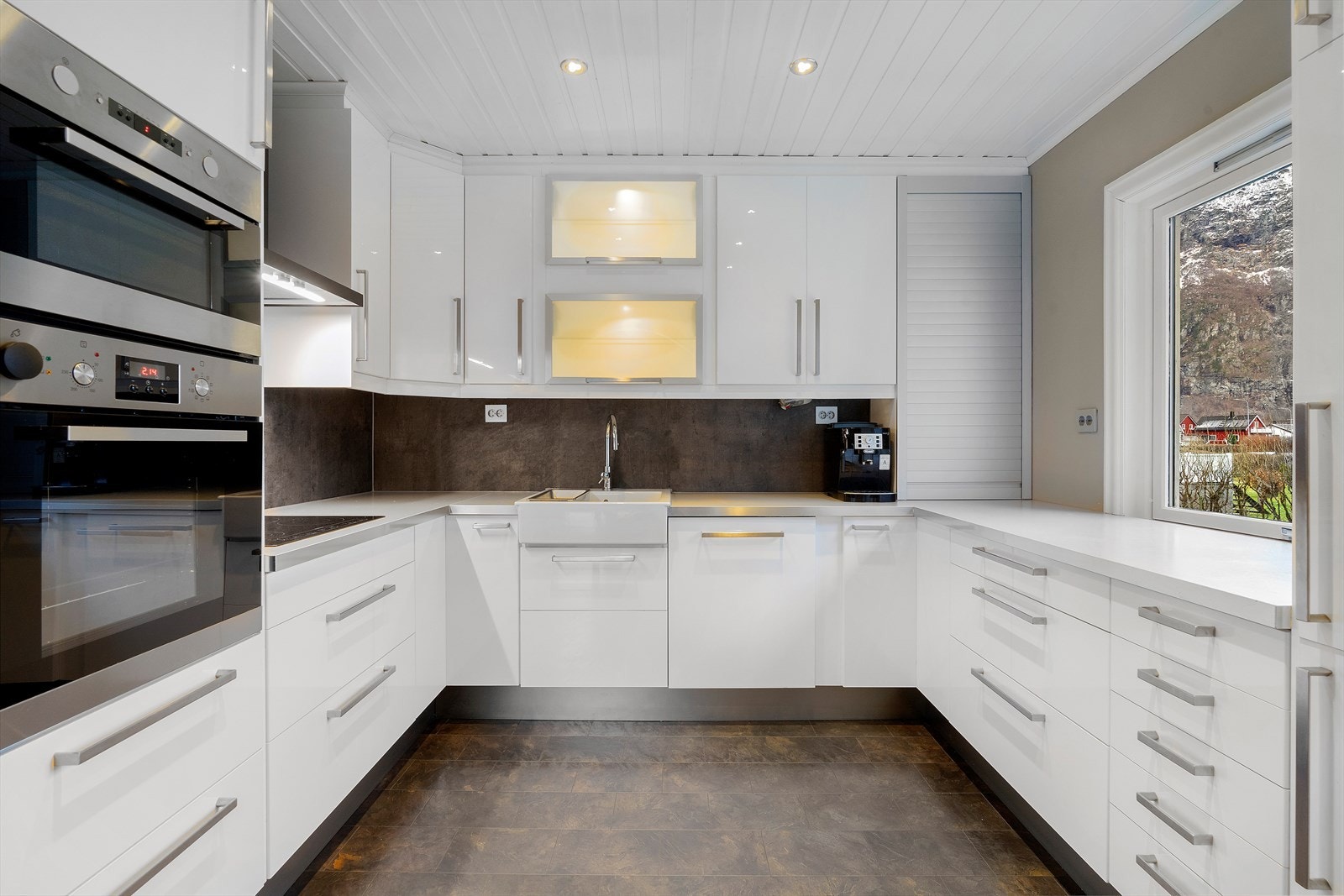 Integrerte hvitevarer og enkel, lys benkeplate gir ryddig arbeidsflate. Galleribilde