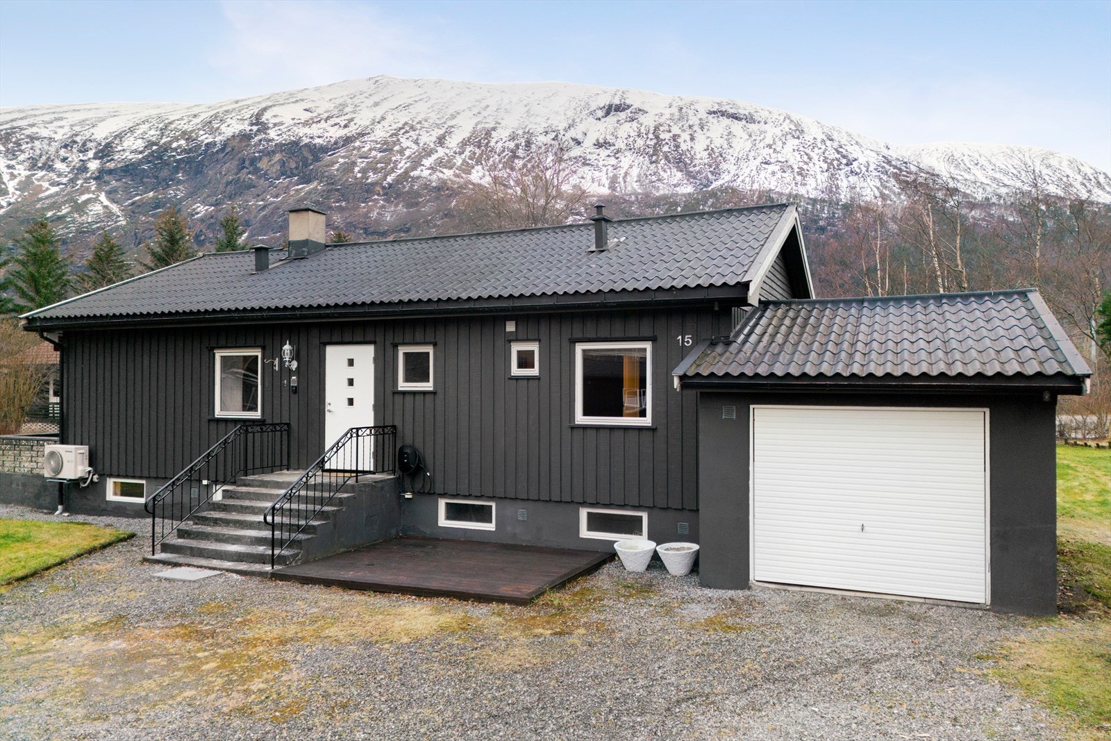 Garasje med tilhørende gruslagt innkjørsel gir praktisk parkering. Galleribilde