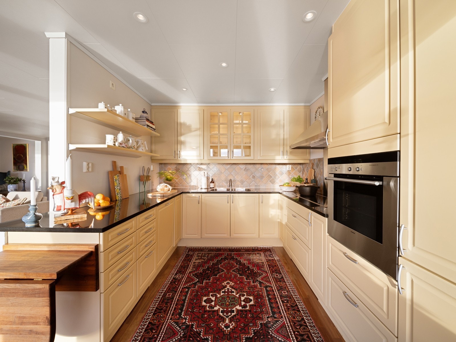 Kjøkkenet er romslig og byr på rikelig med skap- og benkeplass, med innredning i profilerte fronter og benkeplate i stein Galleribilde