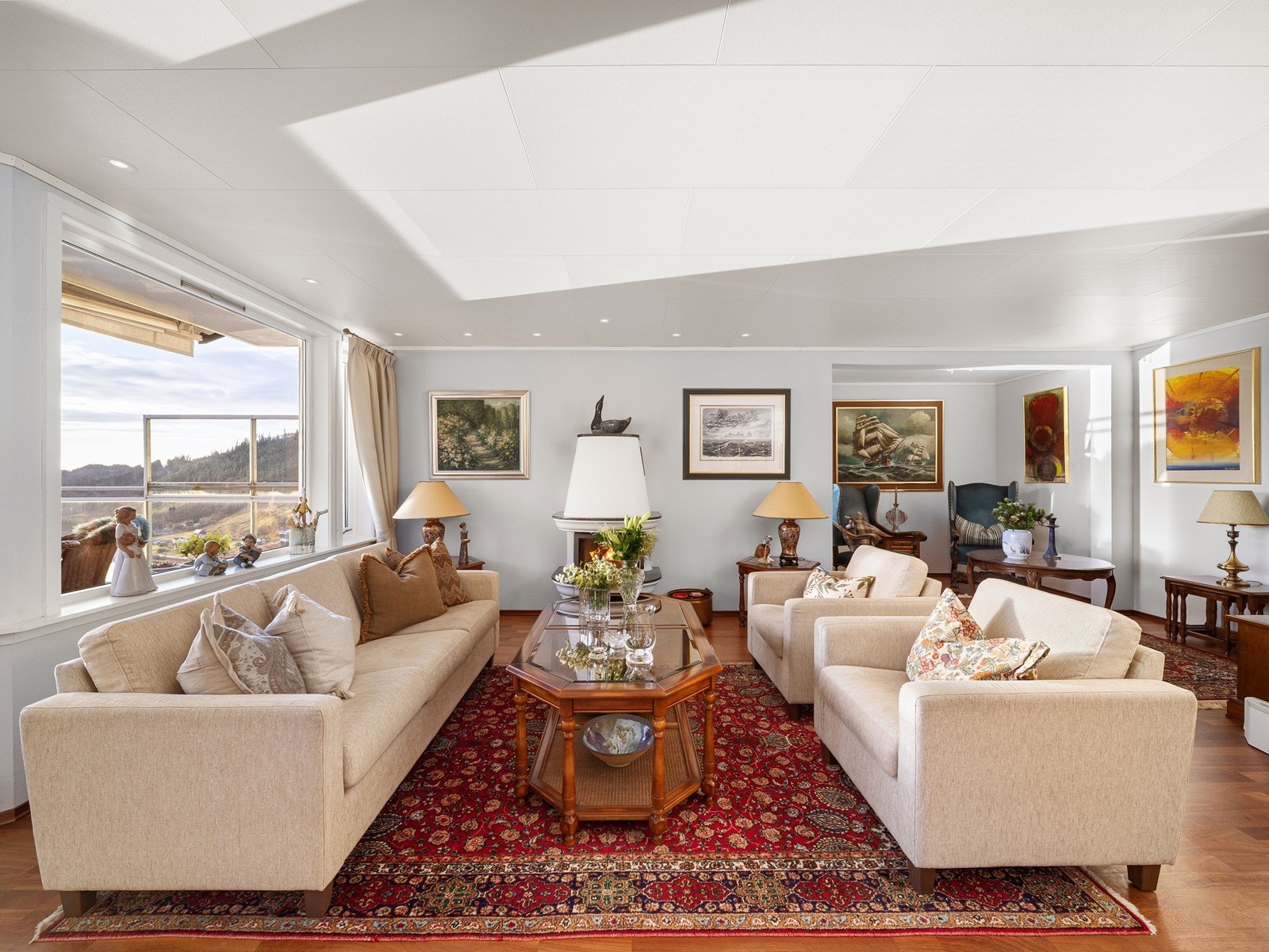 Her er det spotter i himlingen, lyse veggflater og parkett på gulv, samt vedovn som gir både varme og en hyggelig atmosfære Galleribilde