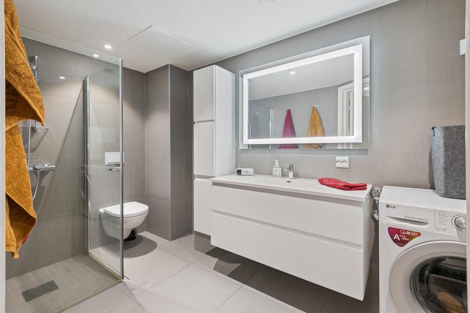 Romslig og flislagt bad med opplegg for vaskemaskin. Galleribilde