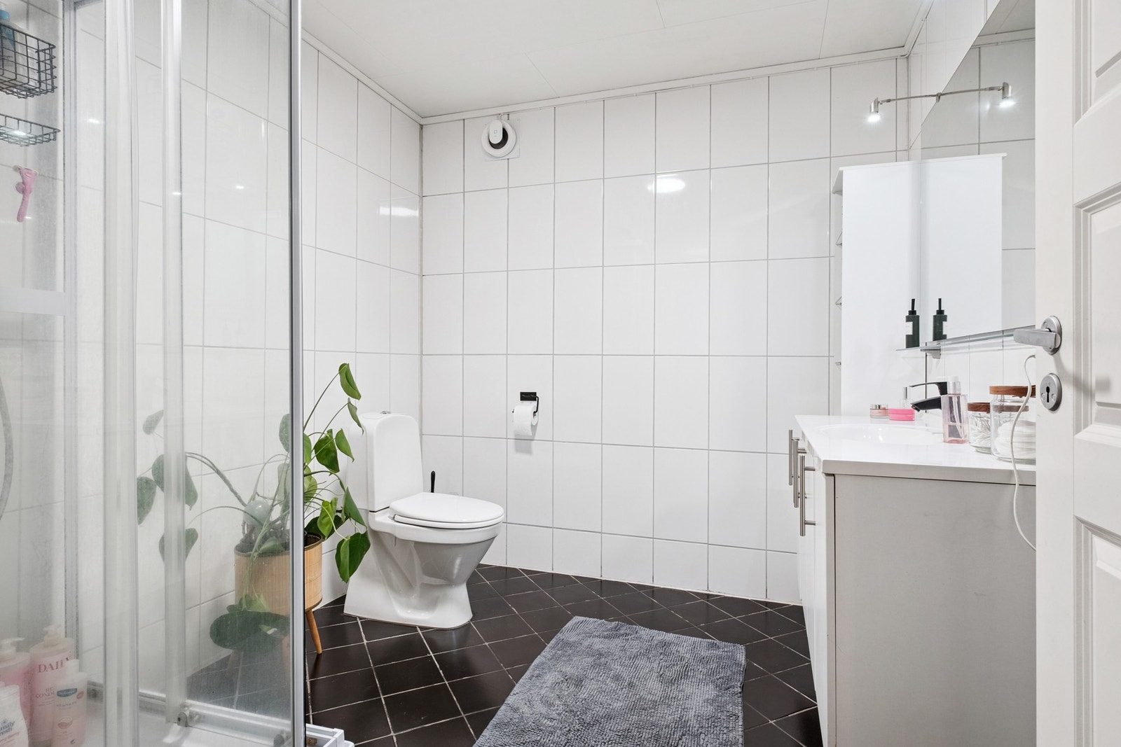 Romslig og flislagt bad med dusjkabinett og en romslig baderomsinnredning med mye lagringsplass. Galleribilde