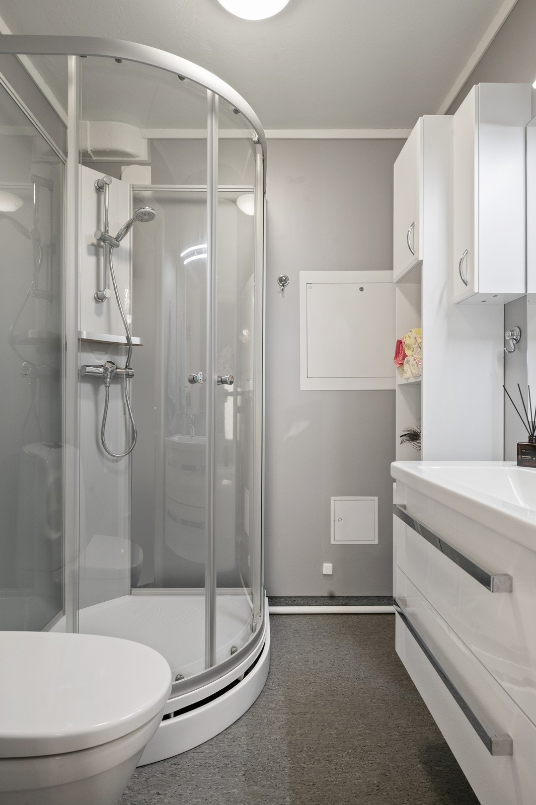 Badet er funksjonelt innredet med dusjkabinett og servant med god skapplass. Galleribilde