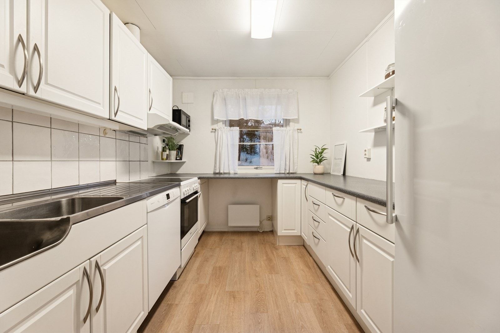 Kjøkkenet er adskilt fra stuen og har godt med skap- og benkeplass. Galleribilde