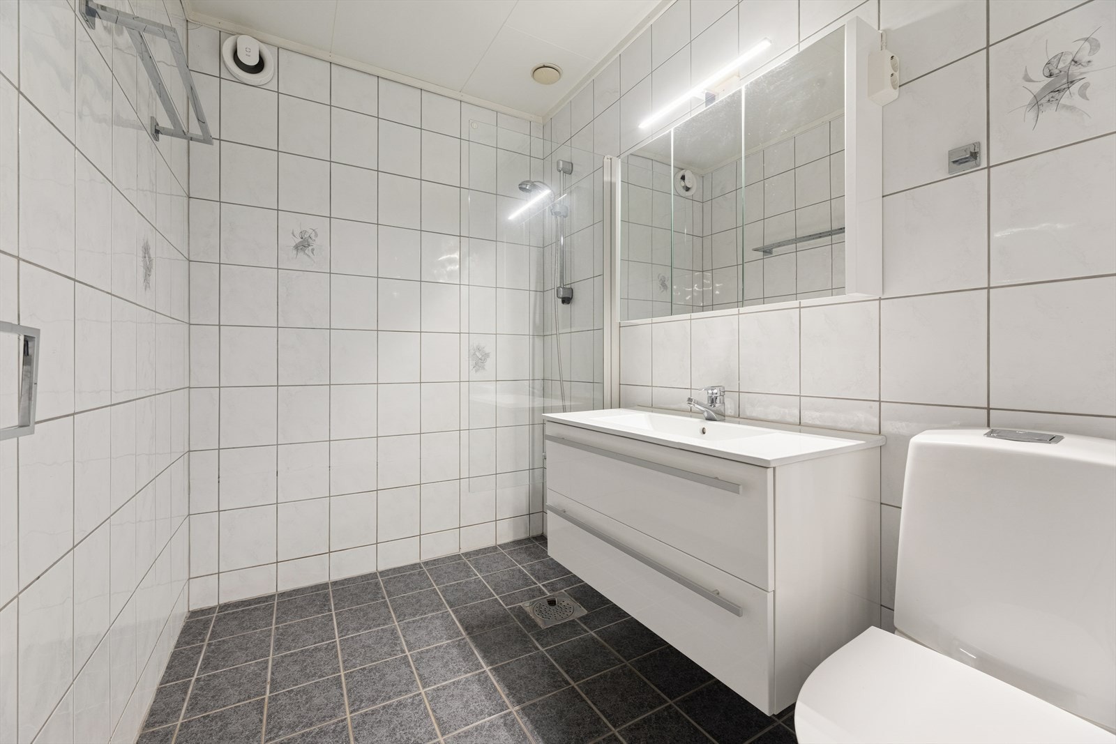 Badet ligger i underetasjen og har flislagte overflater og elektriske varmekabler i gulv. Galleribilde