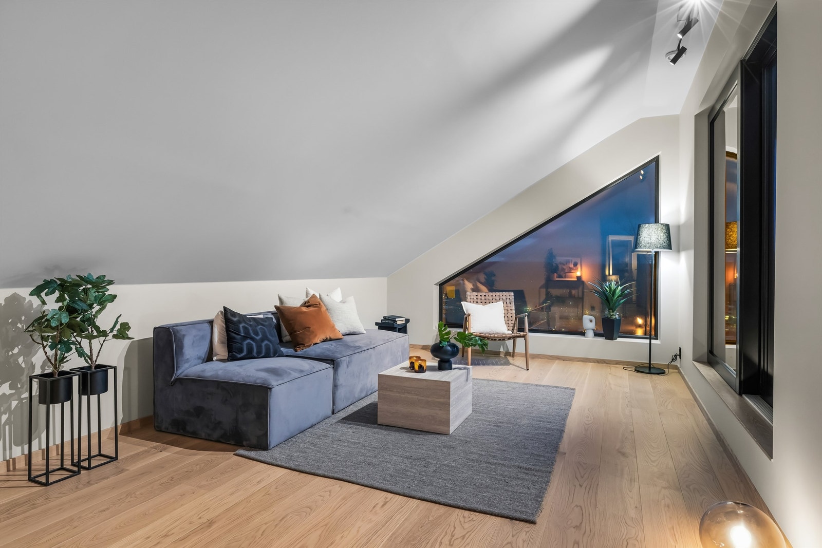 Lys og trivelig loftstue som gir et ekstra oppholdsrom til lek, avslapning eller TV-krok. Overflatene er holdt i samme gjennomførte stil som resten av boligen Galleribilde