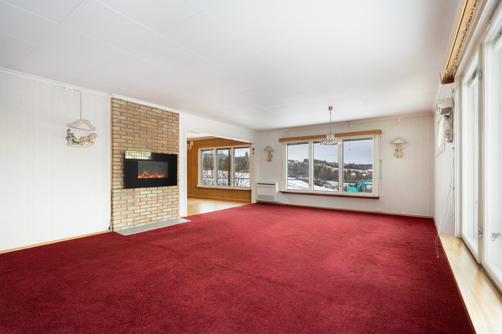 Den andre delen av stuen er romslig og har en peisomramming i teglstein. Galleribilde