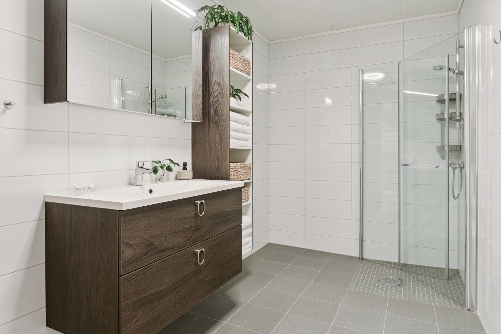 Stilfull innreiing med heildekkjande servant og store skuffer. Speilskap er praktisk og gjev plass til det ein brukar dagleg Galleribilde