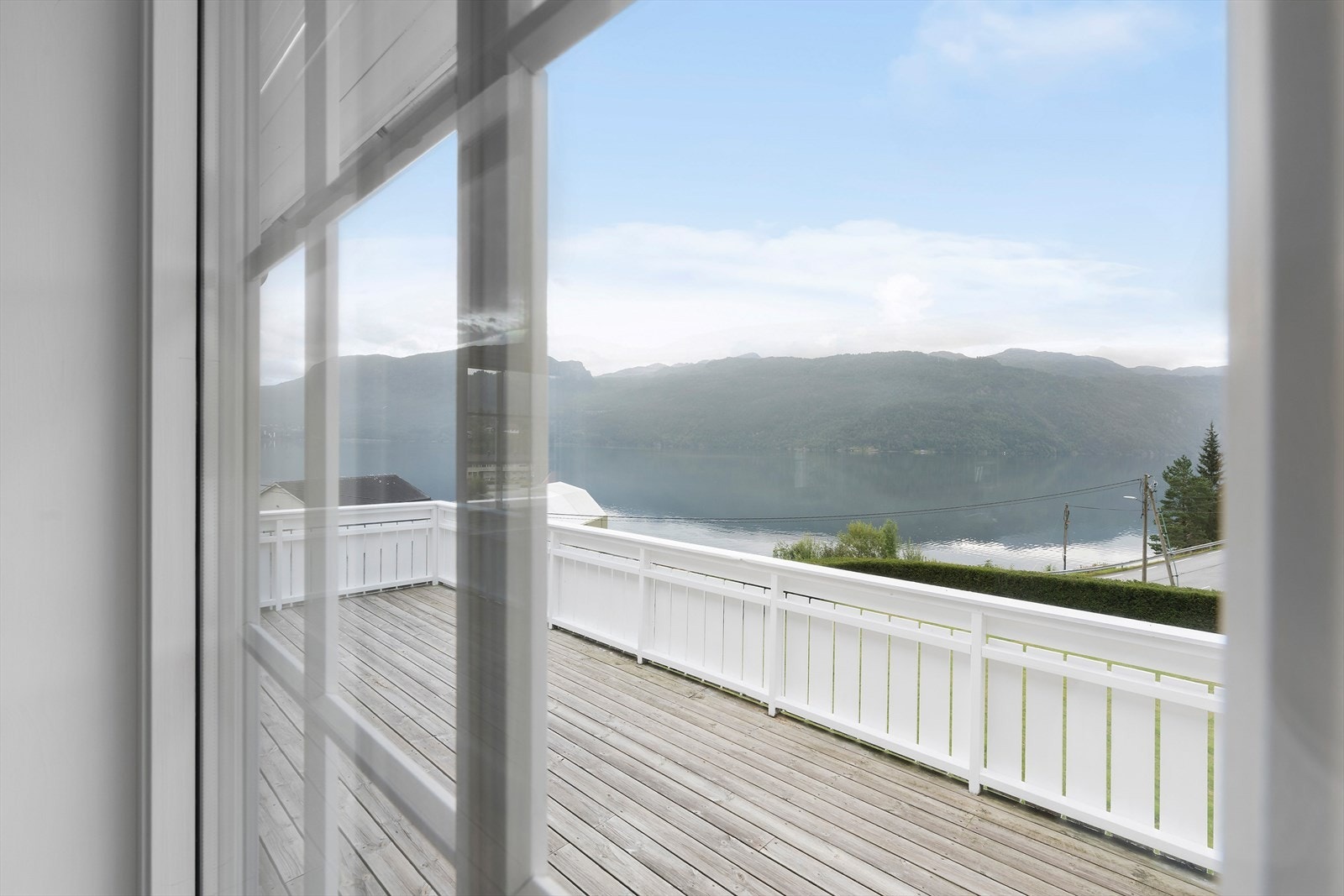 Utgang til terrasse fra stuen. Nydelig utsikt! Det er utvendig screens/solskjerming på stuevinduene som gir god solskjerming (beholder utsyn) Galleribilde