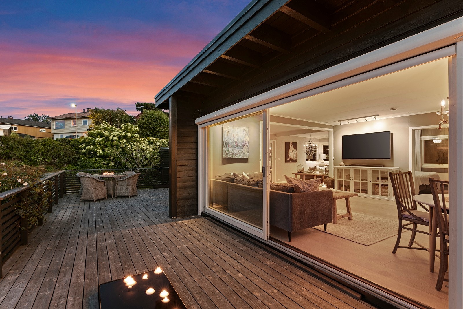 På varme sommerdager kan den store skyvedøren åpnes mot terrassen, og uteområdet blir en naturlig forlengelse av stuen. Galleribilde