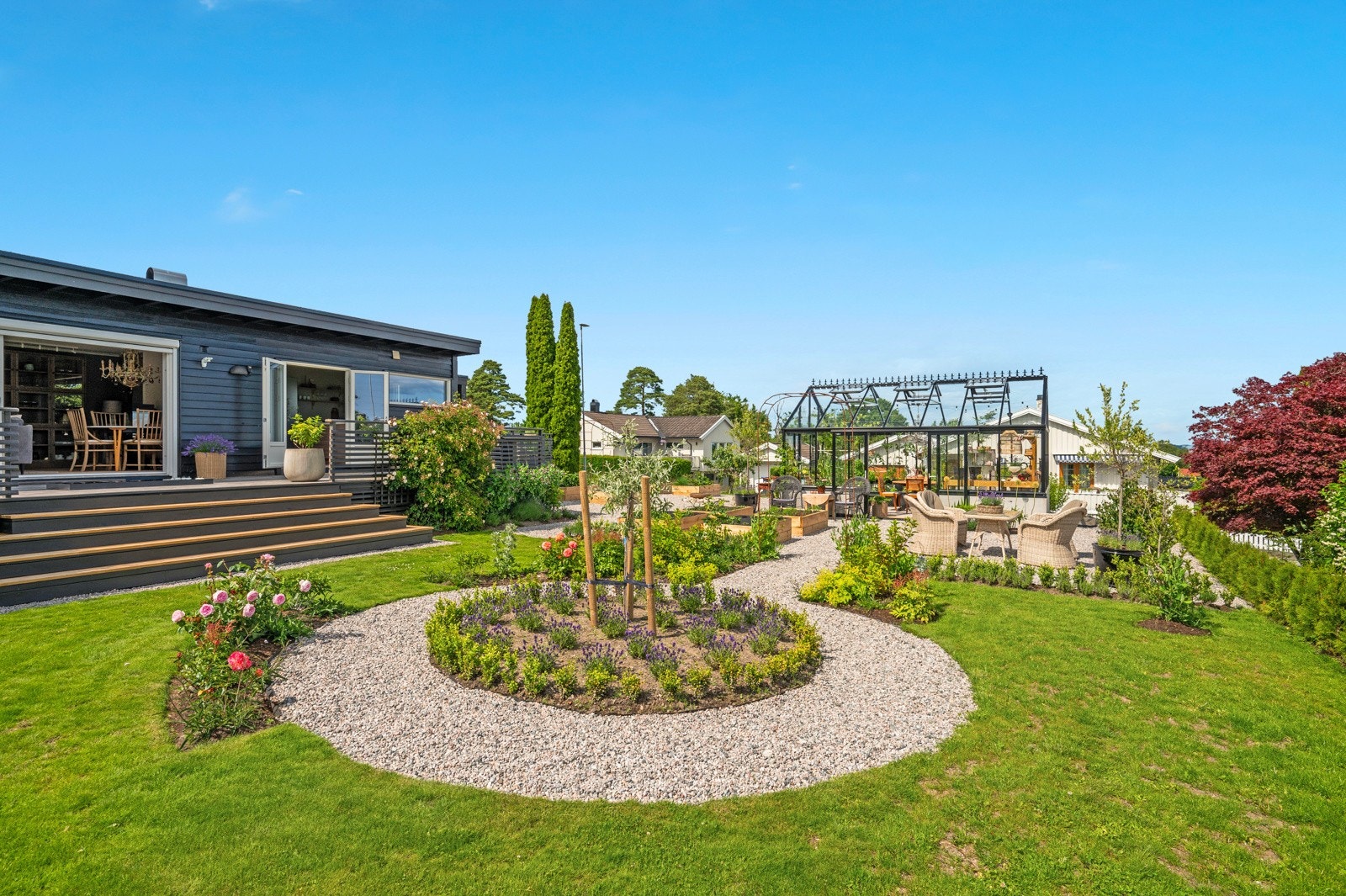 Den innbydende hagen er både solrik og velstelt, med drivhus, grønnsakskasser og god plass til å dyrke hageinteressen. Galleribilde