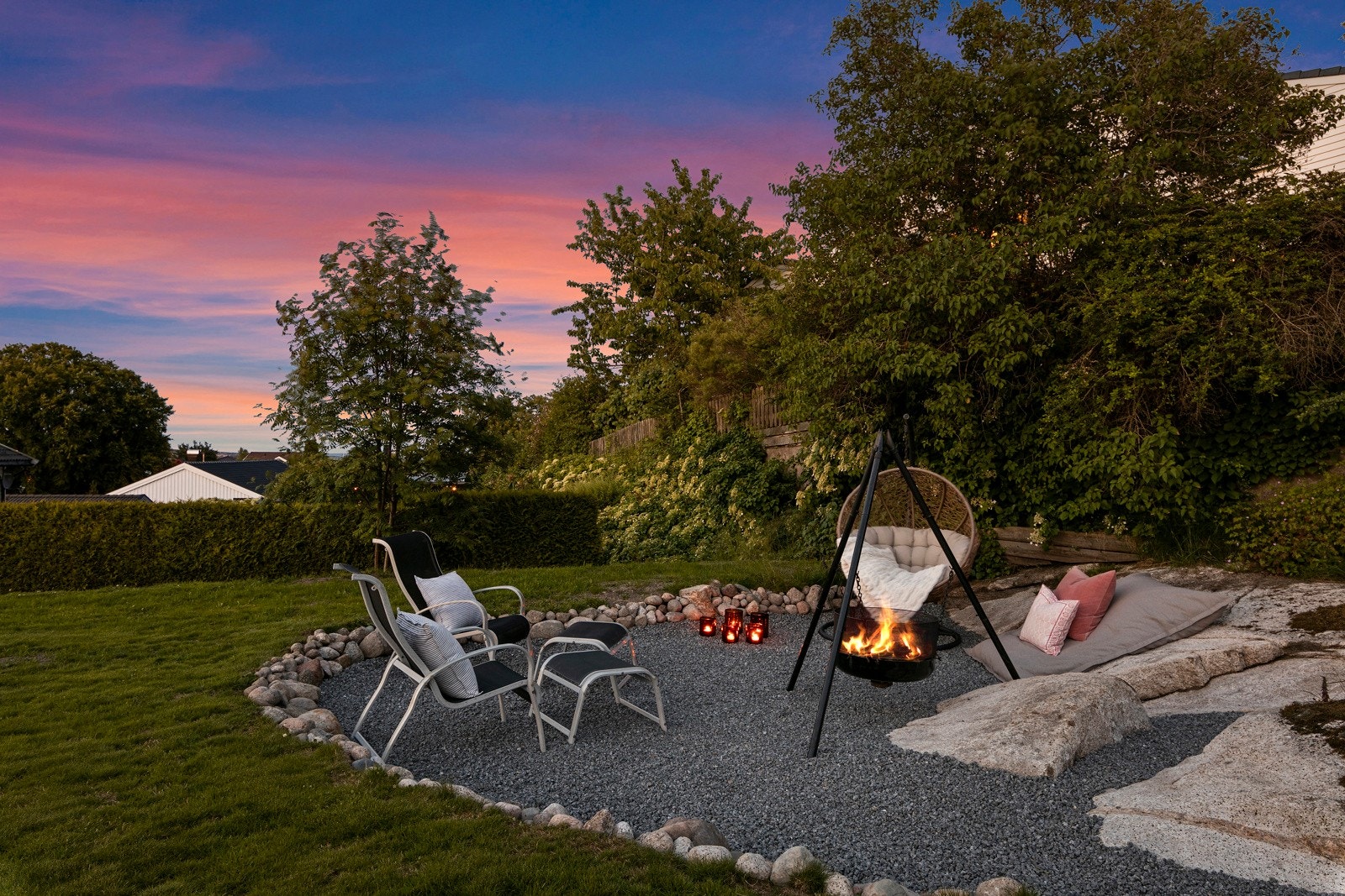 Tomten er pent opparbeidet med en kombinasjon av belegningsstein, asfalt, plen, grus og variert beplantning. Galleribilde