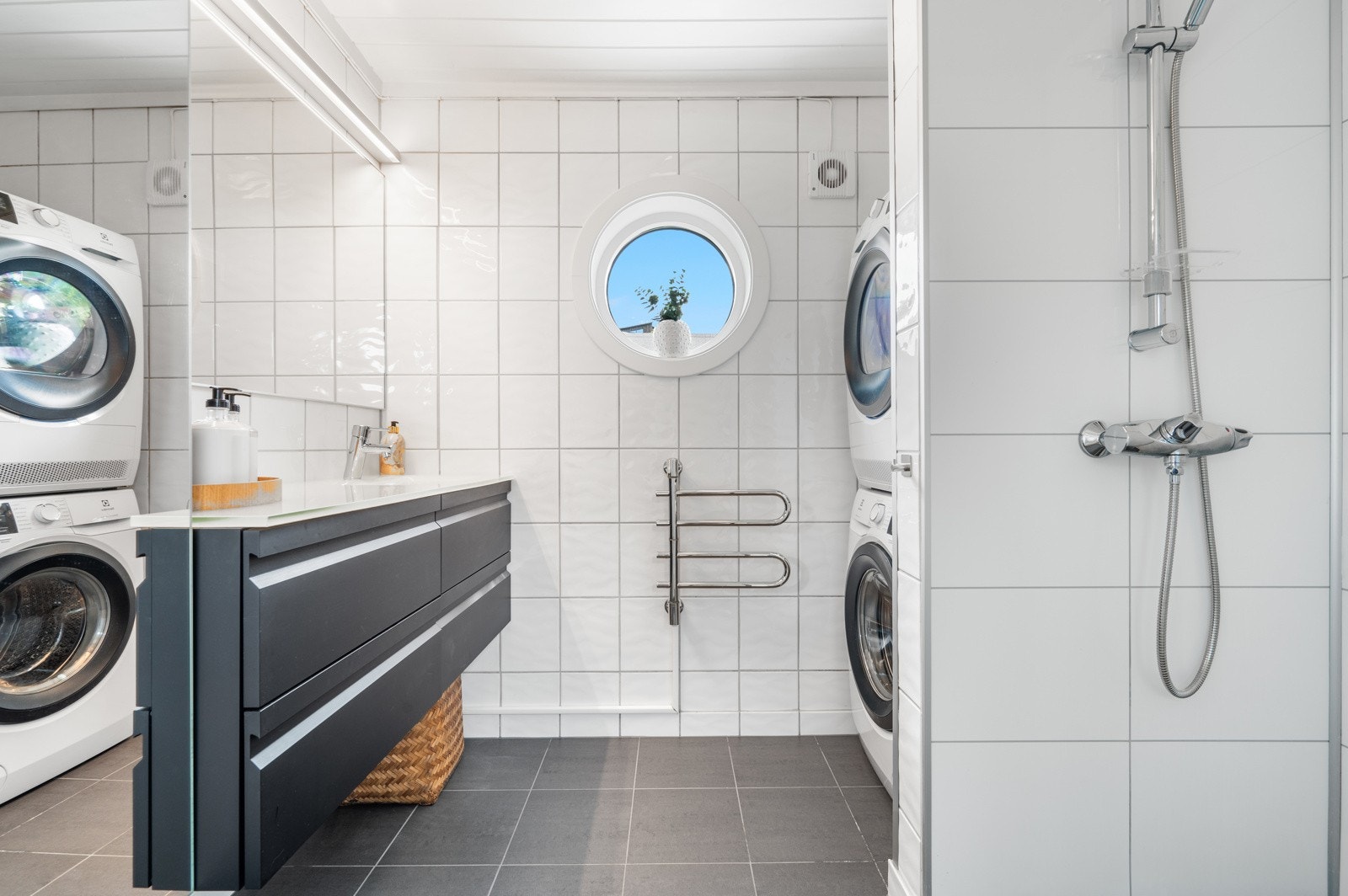 Badet er pent innredet og har plass til vaskemaskin og tørketrommel - en funksjonell detalj som bidrar til en smidig hverdag. Galleribilde