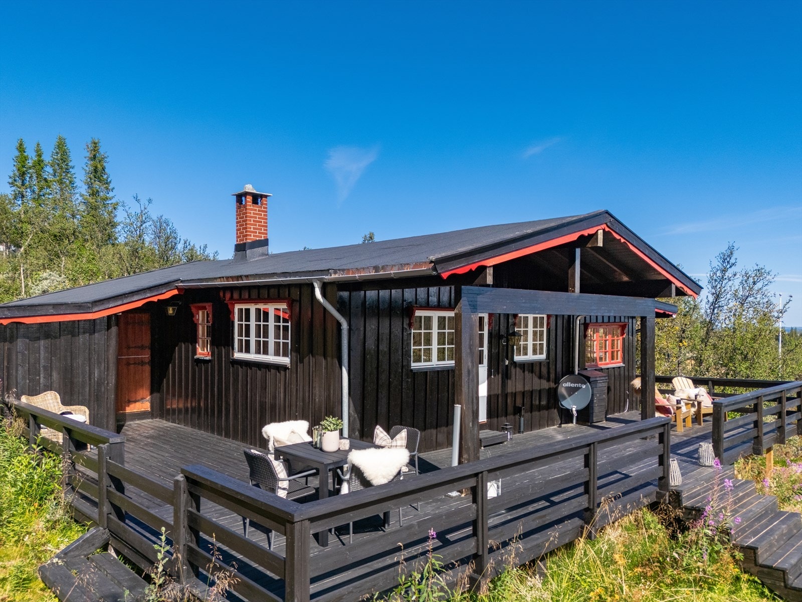 Overbygd inngangsparti, i forbindelse med terrassen som går langs hele framsiden av hytta. Galleribilde