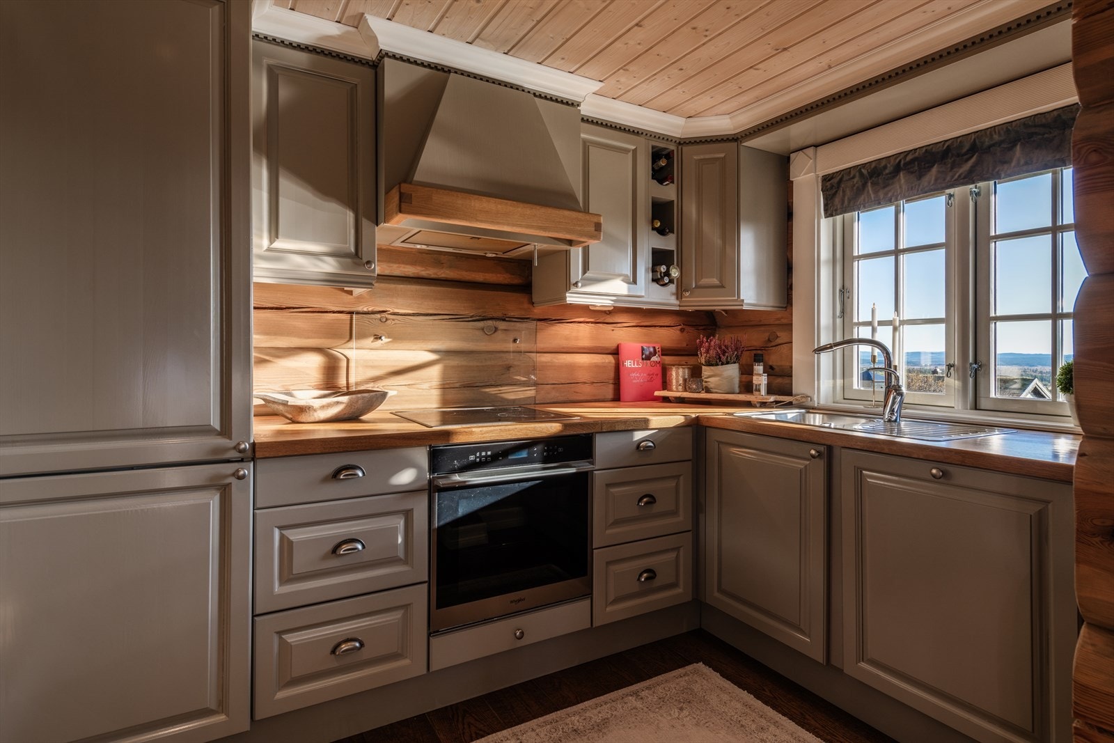 Kjøkkeninnredning med profilerte fronter, heltre benkeplate og nedfelt oppvaskkum. Galleribilde