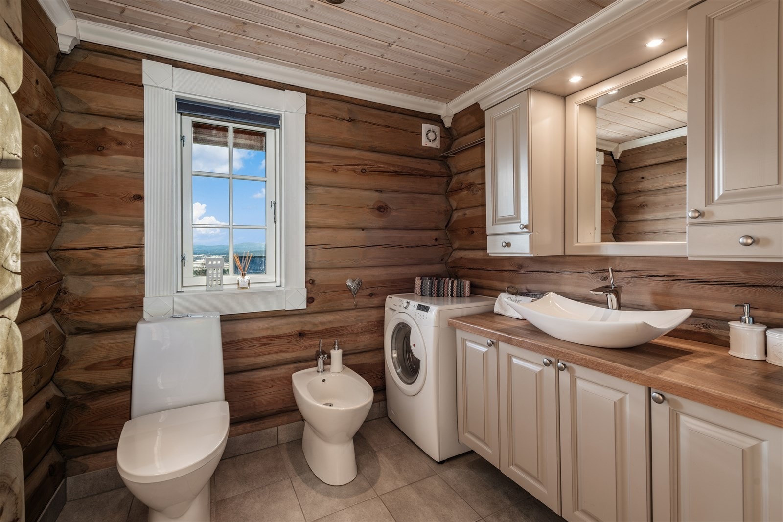 Baderom med flislagt gulv og tømmervegger, som skaper det gode hyttepreget. Galleribilde