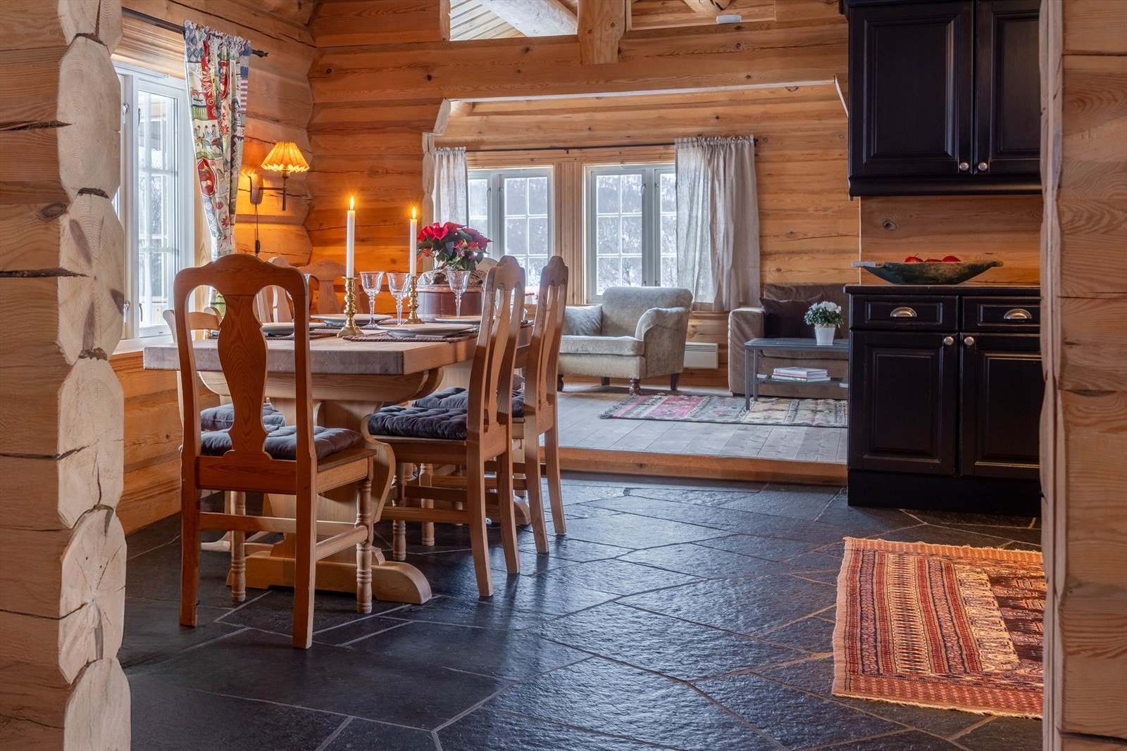 Et innbydende kjøkken hvor måltider tilberedes i ro og godt selskap, Her samles man rundt bordet, med fjellene som et naturlig lerret utenfor vinduet. Galleribilde